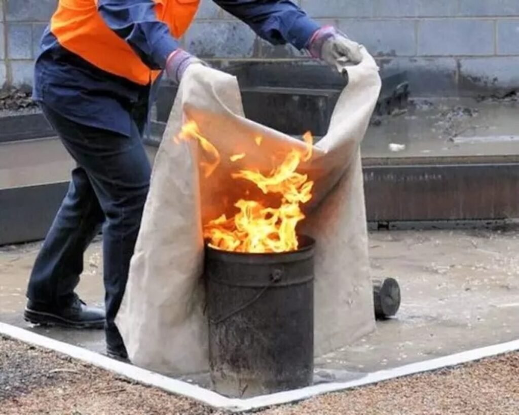 How does a fire blanket work to extinguish fires?